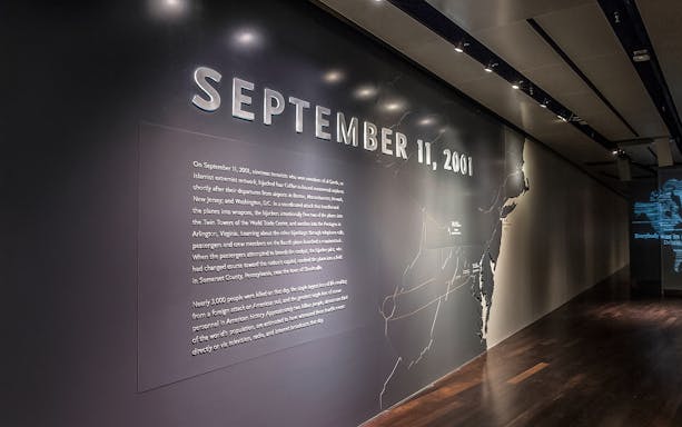 911 Memorial Museum exhibit wall with "September 11, 2001" text and historical information.