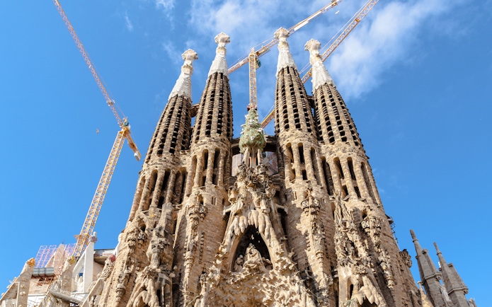 Sagrada Familia towers with cranes against blue sky, Barcelona.
