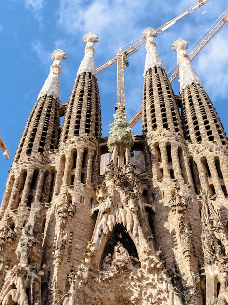Sagrada Familia towers with cranes against blue sky, Barcelona.