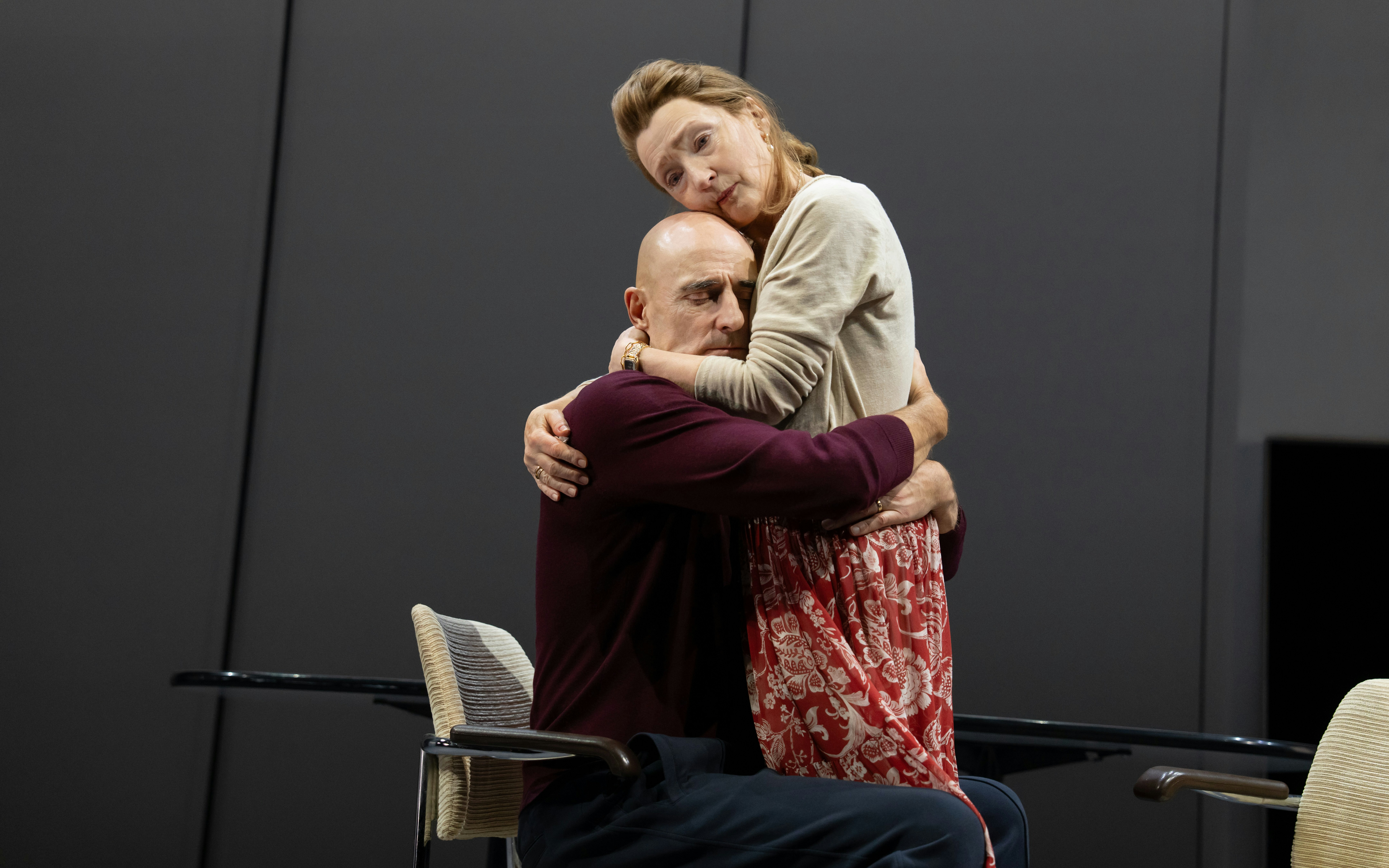 Actors embrace during Oedipus Broadway stage performance.