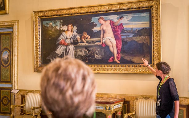 Guide explaining Titian's Sacred and Profane Love painting to visitors at Borghese Gallery, Rome.