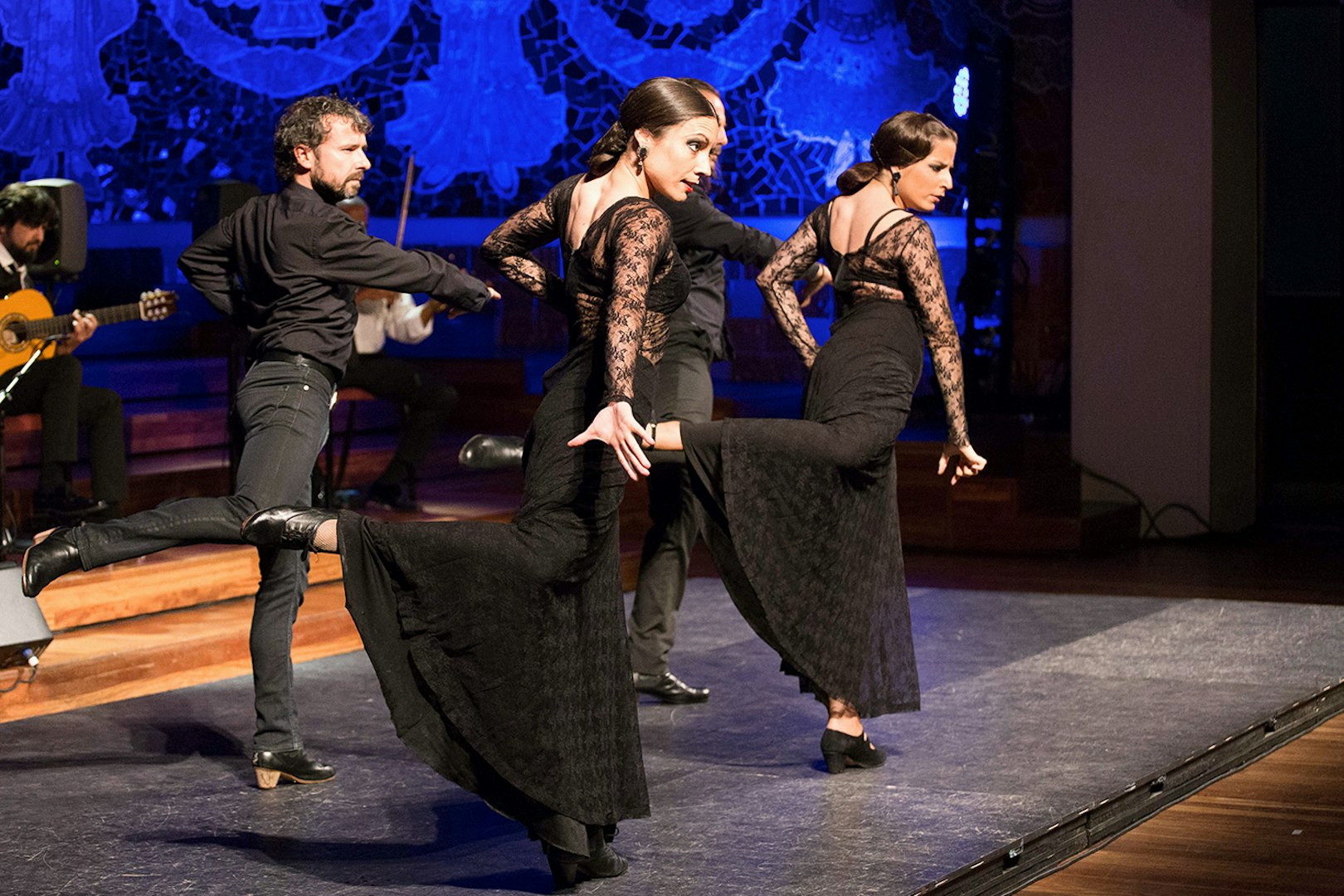 Flamenco dancers performing at Teatro EDP Gran Vía with musicians in the background.