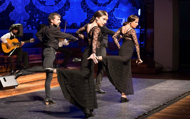 Flamenco dancers performing at Teatro EDP Gran Vía with musicians in the background.