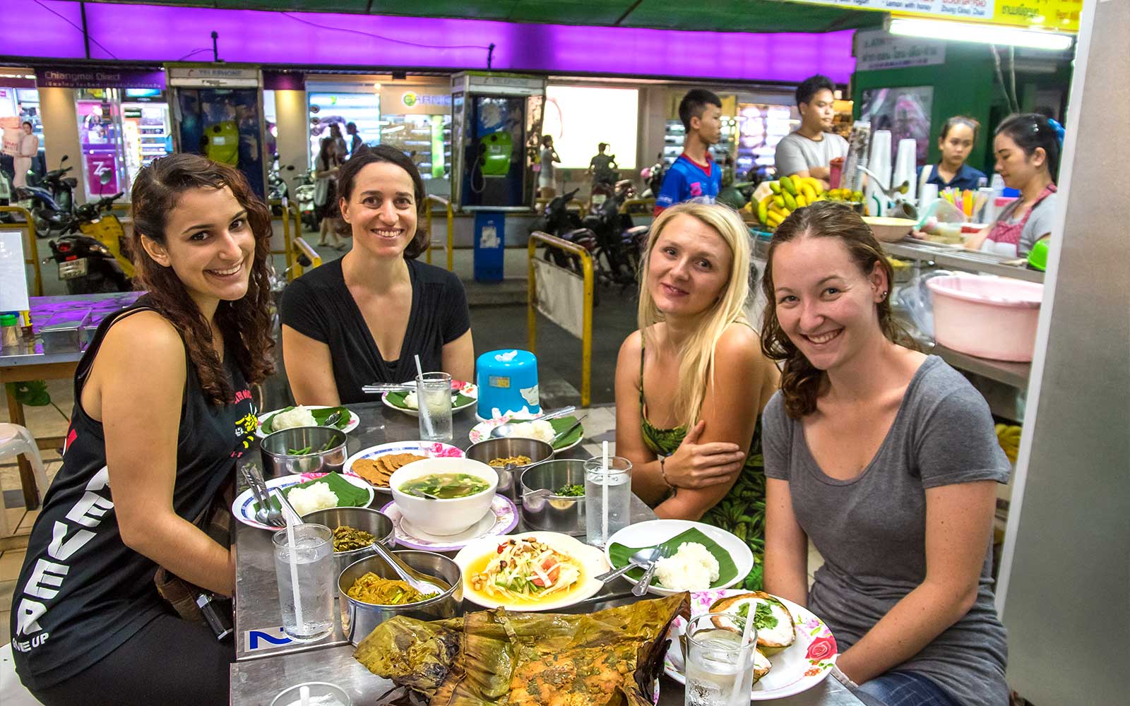 Group enjoying local food at a Chiang Mai night market during a bike tour.