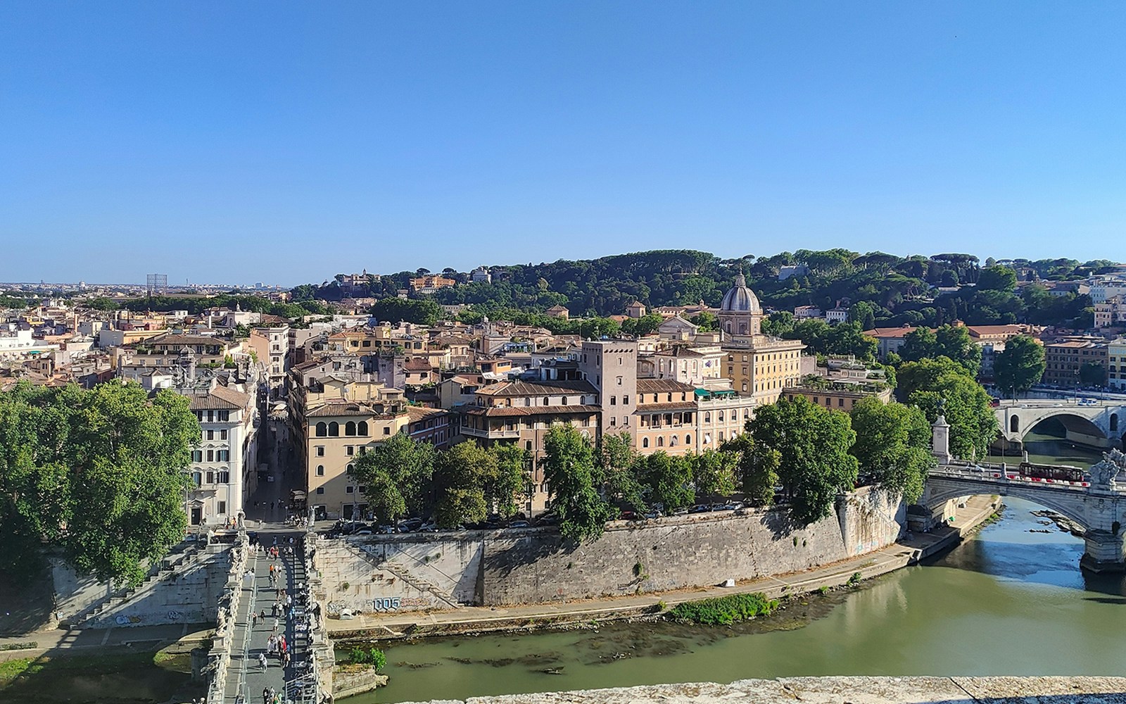 View of Rome from Castel Sant'Angelo, featuring the Tiber River and historic buildings.