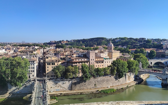 View of Rome from Castel Sant'Angelo, featuring the Tiber River and historic buildings.