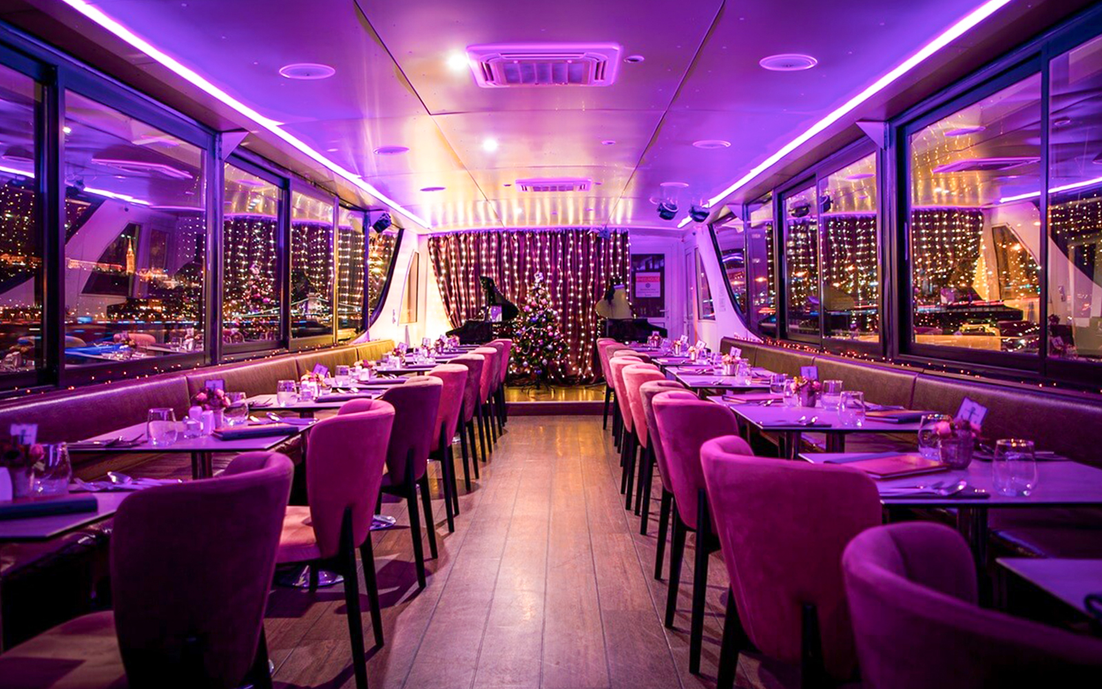 Interior of a Budapest Christmas cruise with festive lights and dining setup.