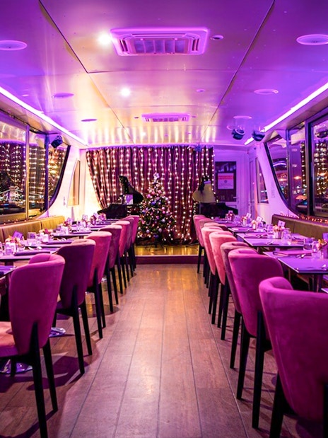 Interior of a Budapest Christmas cruise with festive lights and dining setup.