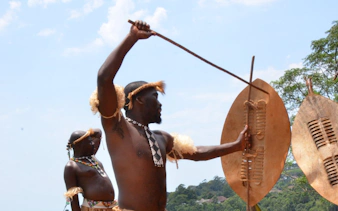 Zulu warriors performing traditional dance with shields and spears in Durban.
