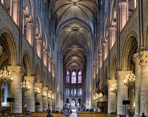 Notre Dame Cathedral interior with stained glass windows and vaulted ceilings, Paris, France.