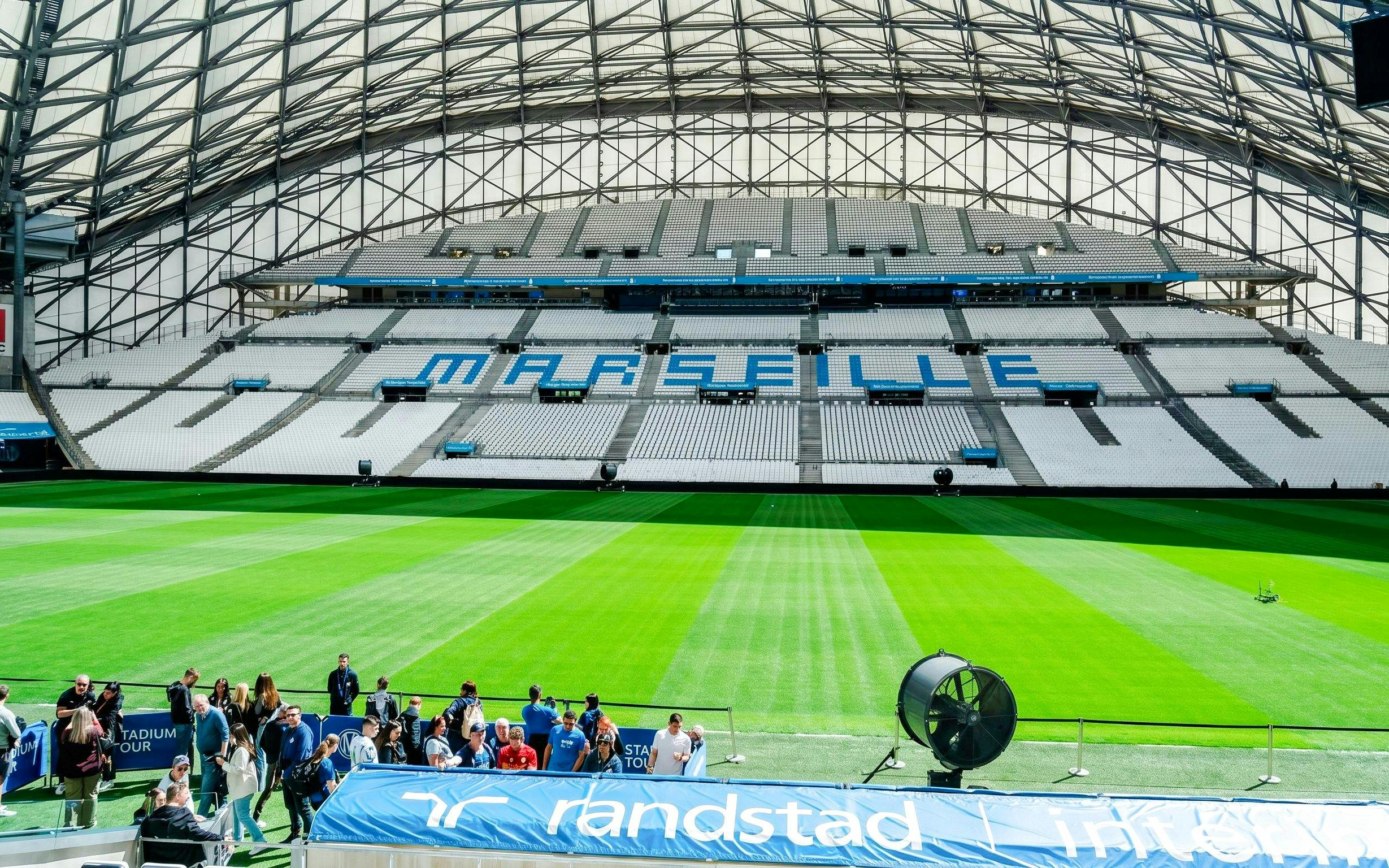 Stadium seating and field at OM Stadium in Marseille during a tour.