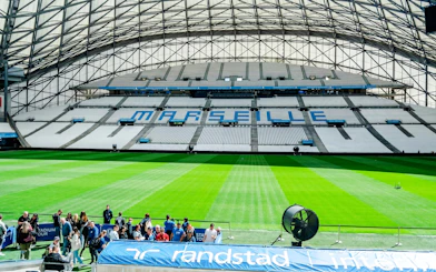 Stadium seating and field at OM Stadium in Marseille during a tour.