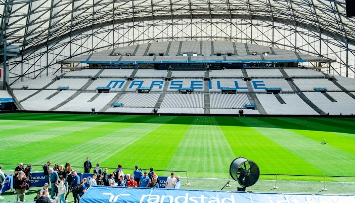 Stadium seating and field at OM Stadium in Marseille during a tour.