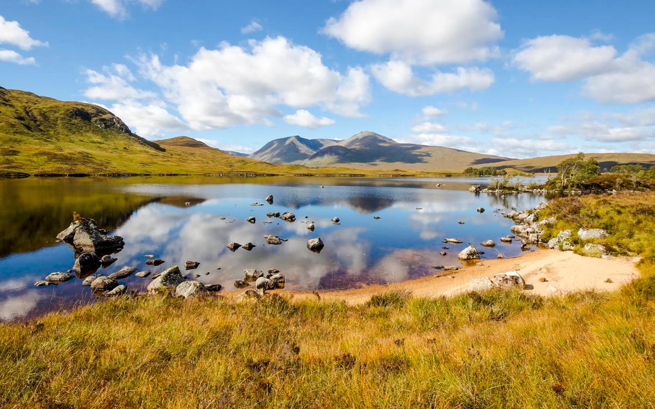 Rannoch Moor landscape with reflective lake and distant mountains in Scotland.