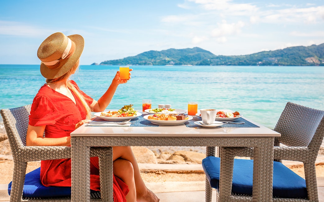 Woman enjoying lunch with ocean view on Phuket Sunset Tour, Phi Phi Island.