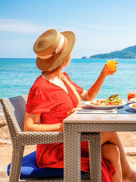 Woman enjoying lunch with ocean view on Phuket Sunset Tour, Phi Phi Island.