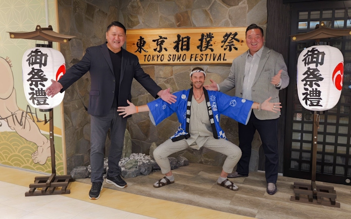 Ginza entrance with sumo show participants posing for souvenir photos.