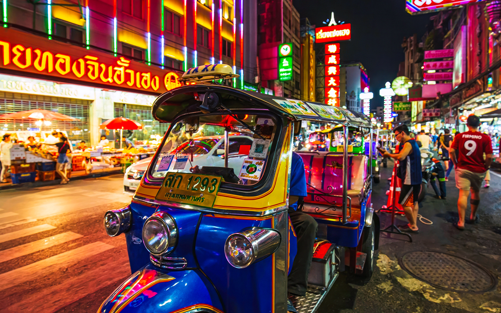 Tuk-tuk on a vibrant street in Bangkok's Chinatown during the night tour.