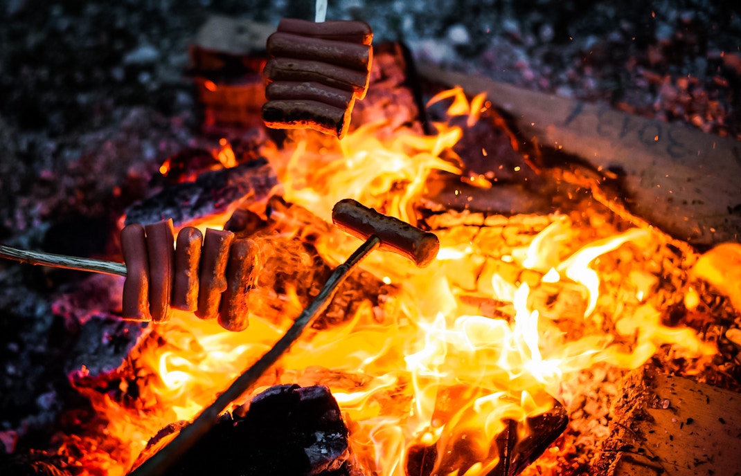 Roasting sausages over a campfire under the Northern Lights.