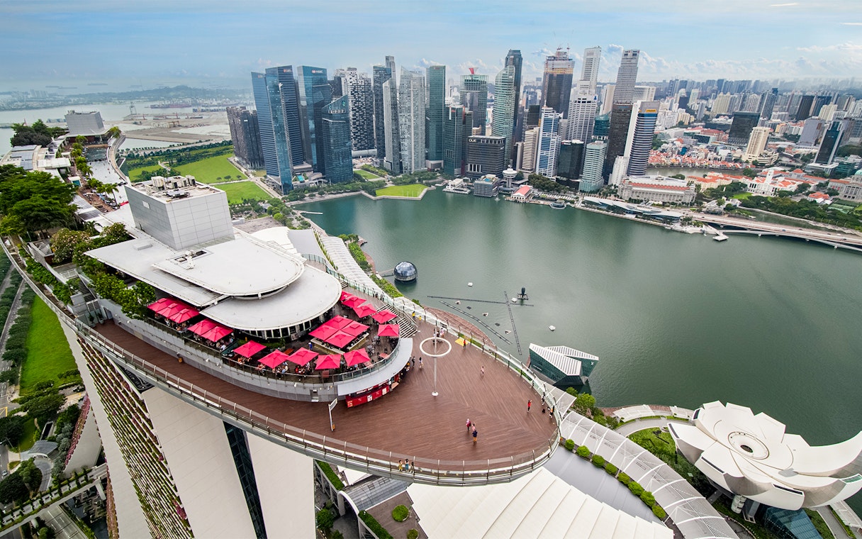 Gardens by the Bay and Marina Bay Sands rooftop view in Singapore with city skyline.