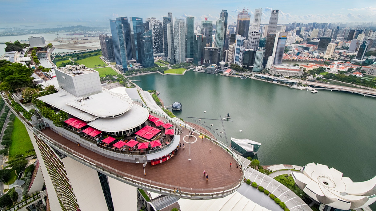 Gardens by the Bay and Marina Bay Sands rooftop view in Singapore with city skyline.
