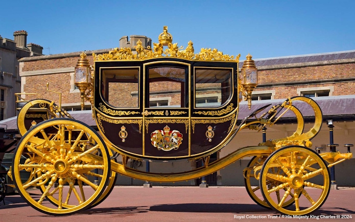 Golden royal carriage at Buckingham Palace courtyard.