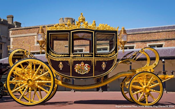 Golden royal carriage at Buckingham Palace courtyard.
