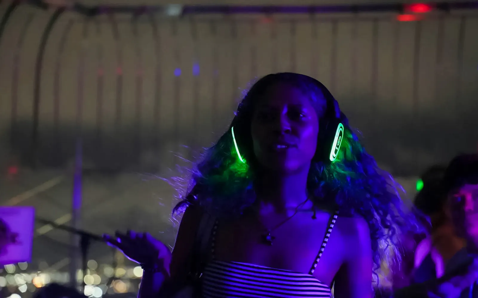Person enjoying silent disco with headphones at Empire State Building Observation Deck.