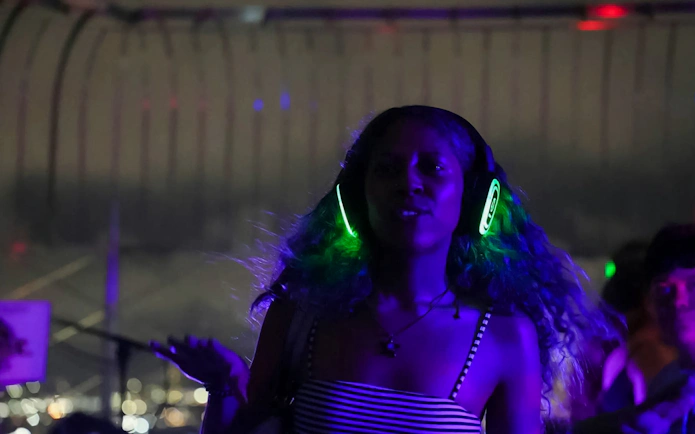 Person enjoying silent disco with headphones at Empire State Building Observation Deck.