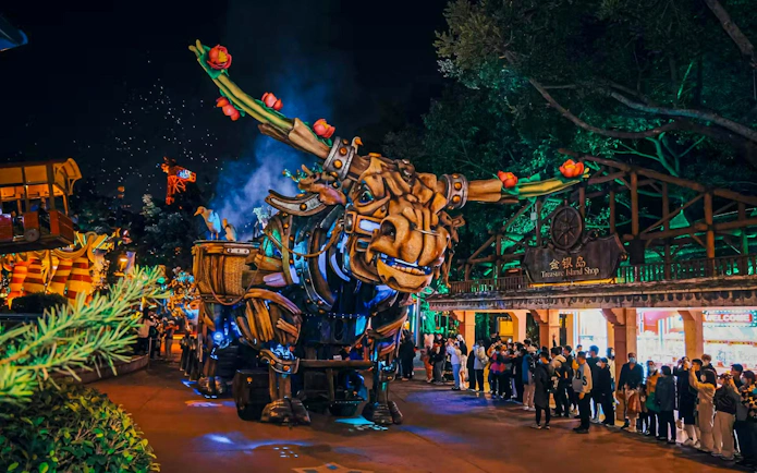 Giant mechanical bull parade at Chimelong Paradise with crowd watching.
