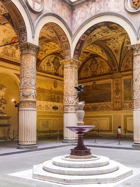 Courtyard of the Palazzo Vecchio with ornate columns and a central fountain in Florence, Italy.