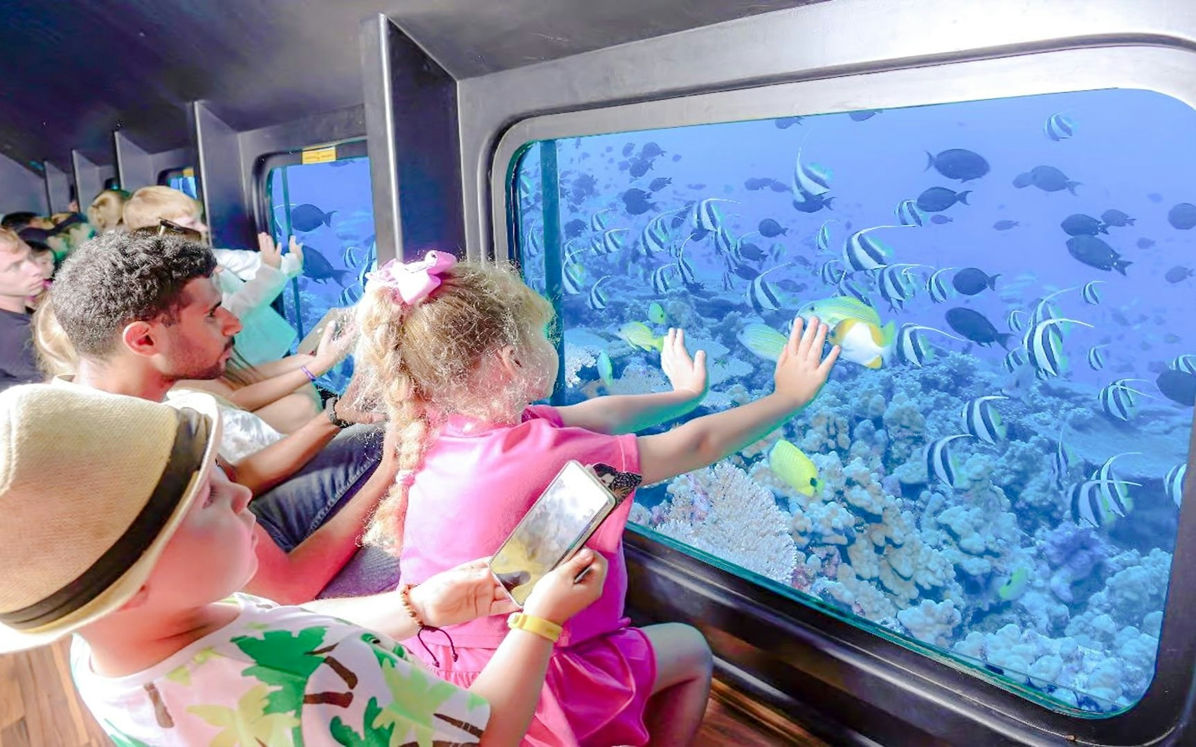 Family viewing fish through semi-submarine window on Royal Seascope tour, Red Sea, Hurghada.