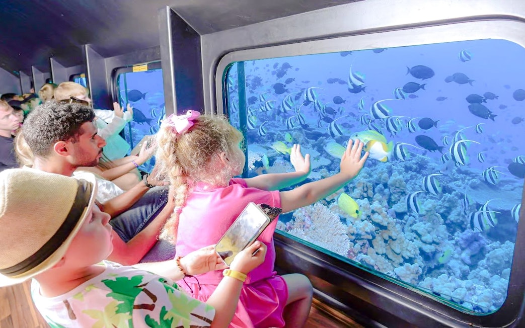 Family viewing fish through semi-submarine window on Royal Seascope tour, Red Sea, Hurghada.