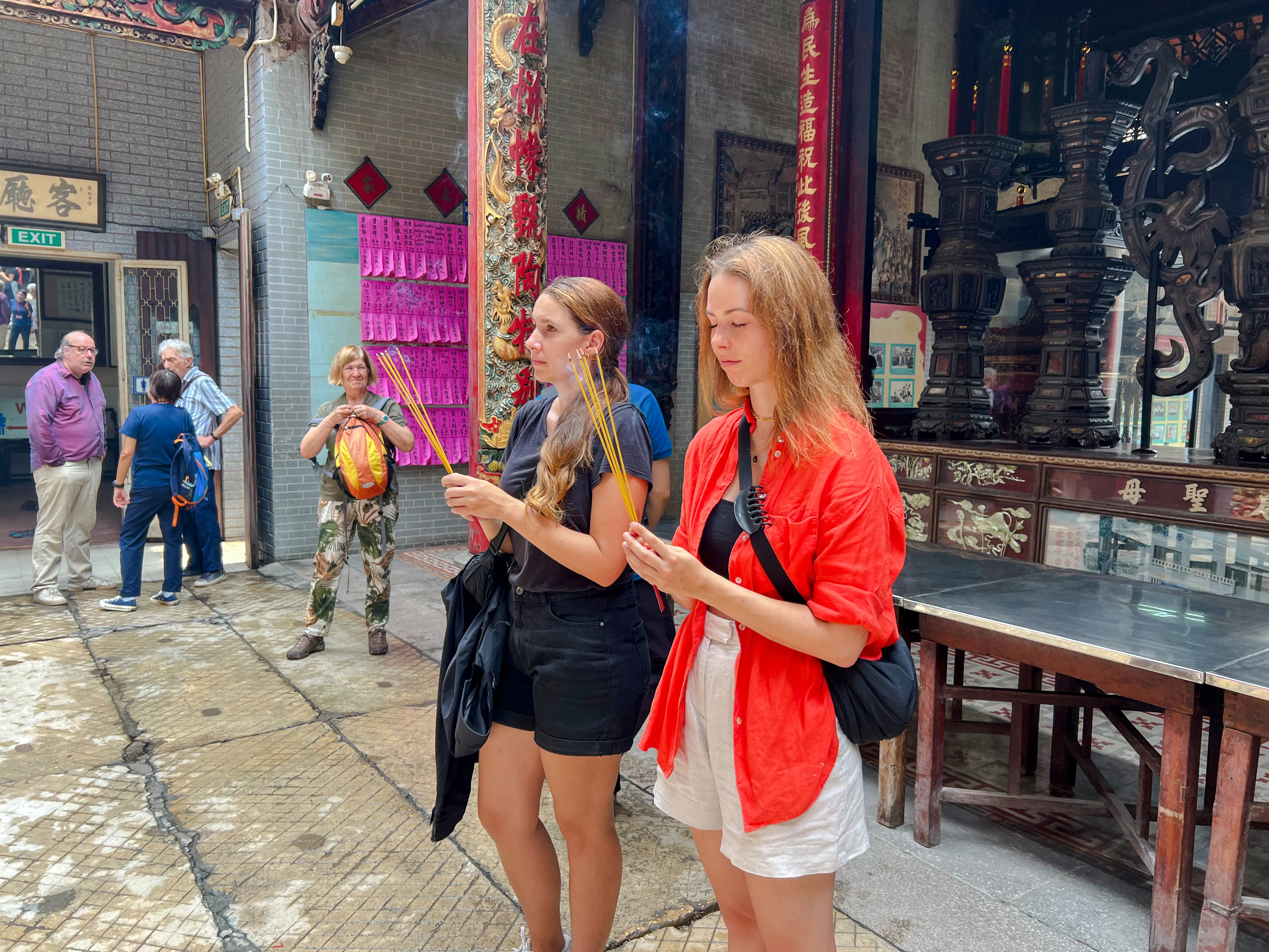 Visitors holding incense sticks at a temple in Ho Chi Minh City during Saigon Hidden Gems Day Tour.