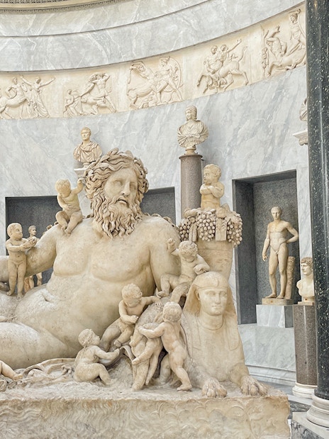 Statue of river god Oceanus surrounded by figures in Vatican Museums.