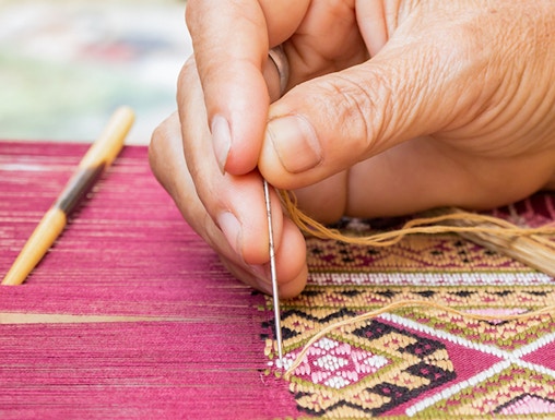Hand weaving intricate silk pattern at Valencia Silk Museum.