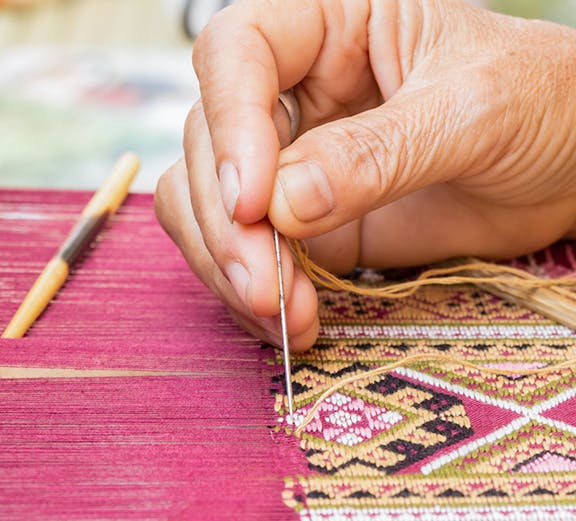 Hand weaving intricate silk pattern at Valencia Silk Museum.