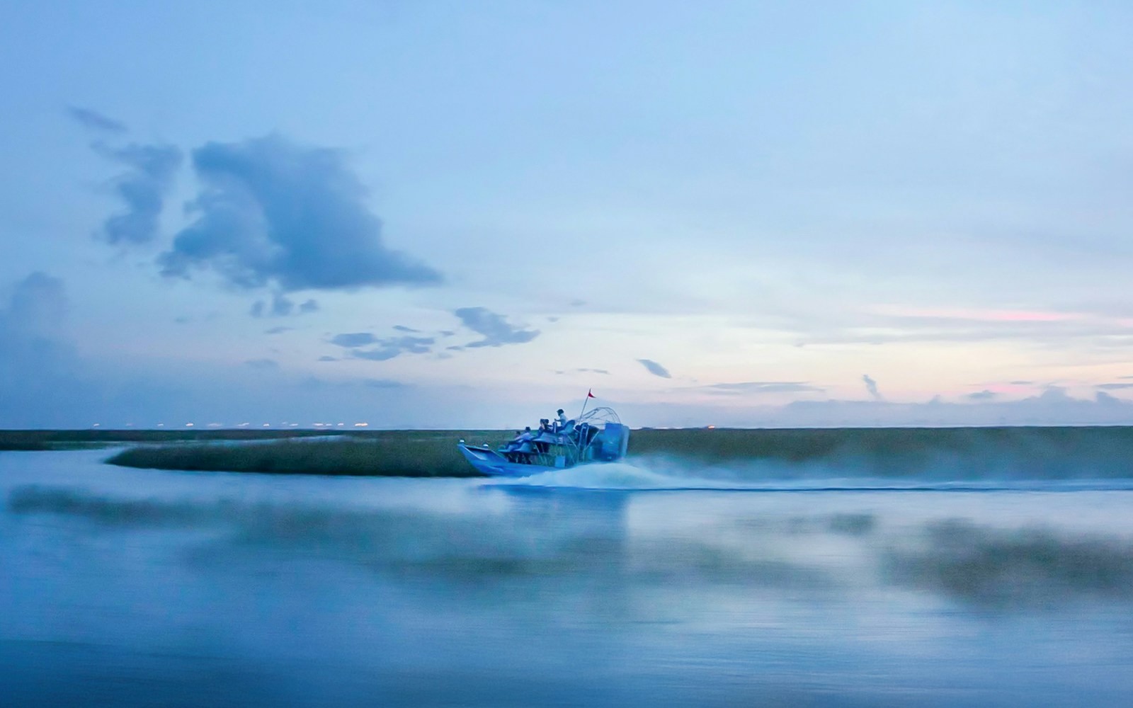 Airboat gliding through Everglades at dusk during night tour.