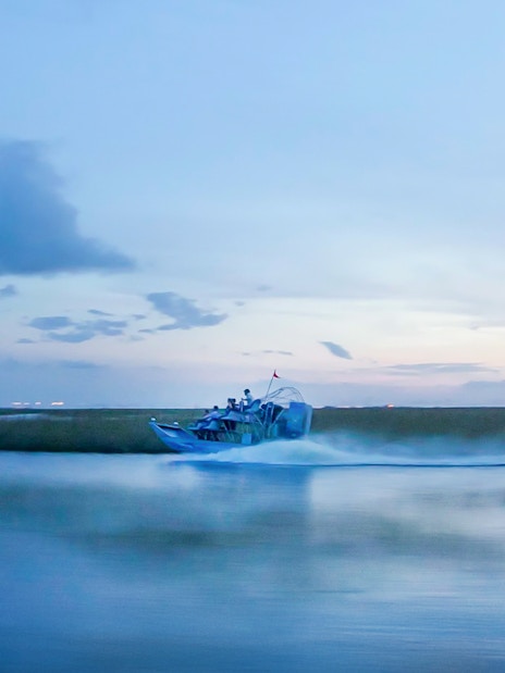 Airboat gliding through Everglades at dusk during night tour.