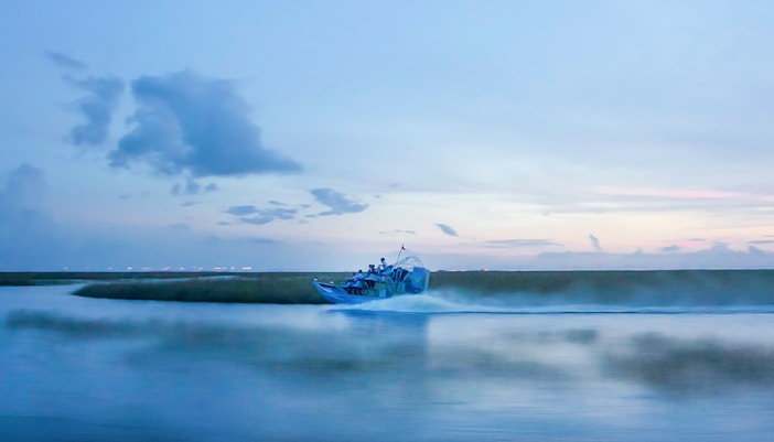 Airboat gliding through Everglades at dusk during night tour.