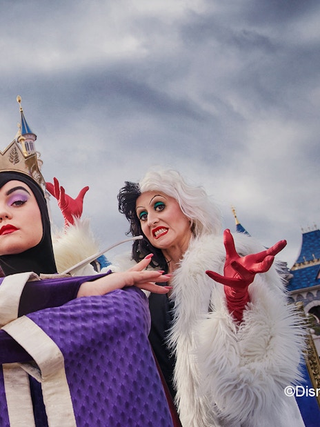 Disney villains posing in front of Sleeping Beauty Castle at Disneyland Paris during Halloween.