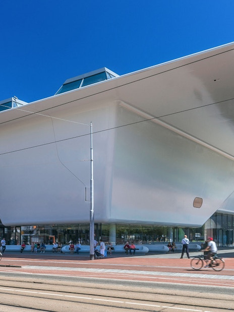 Stedelijk Museum exterior in Amsterdam with modern architecture and people walking nearby.