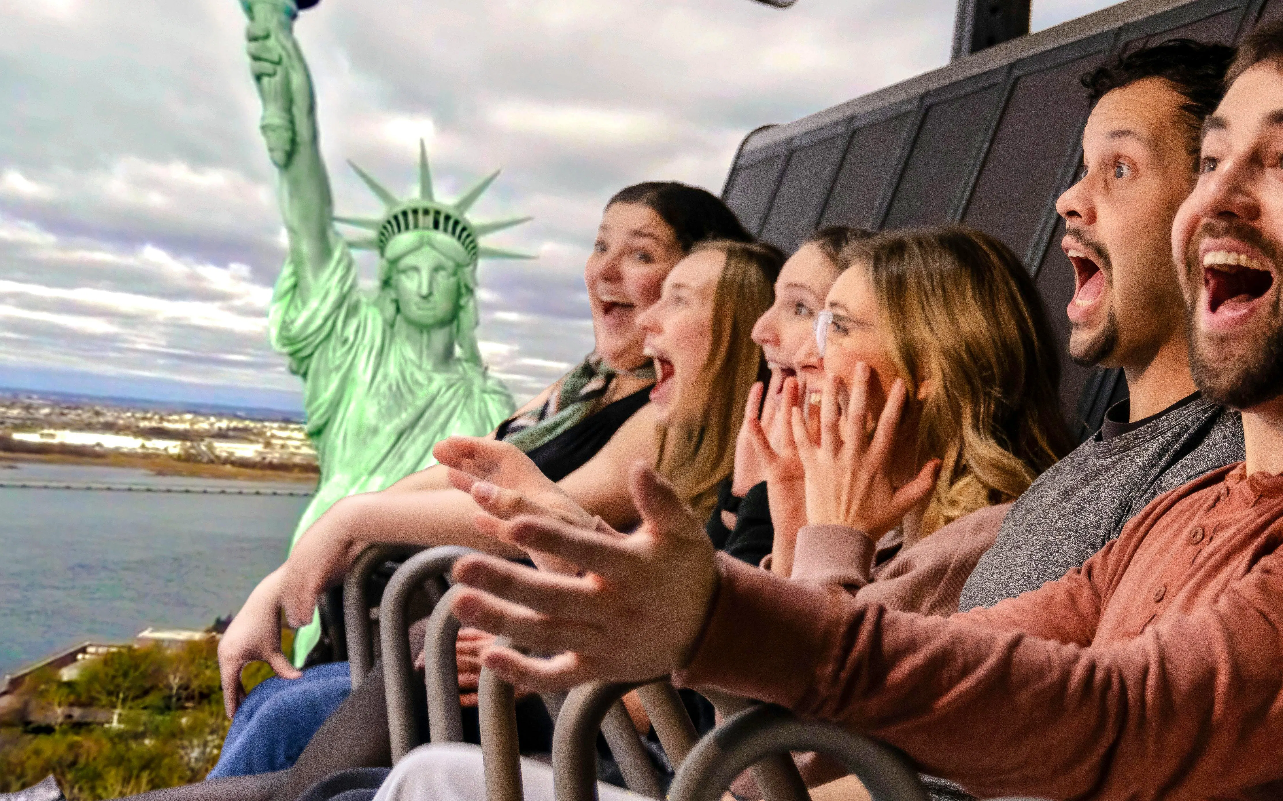 Guests enjoying a simulated ride at RiseNY with a view of the Statue of Liberty.