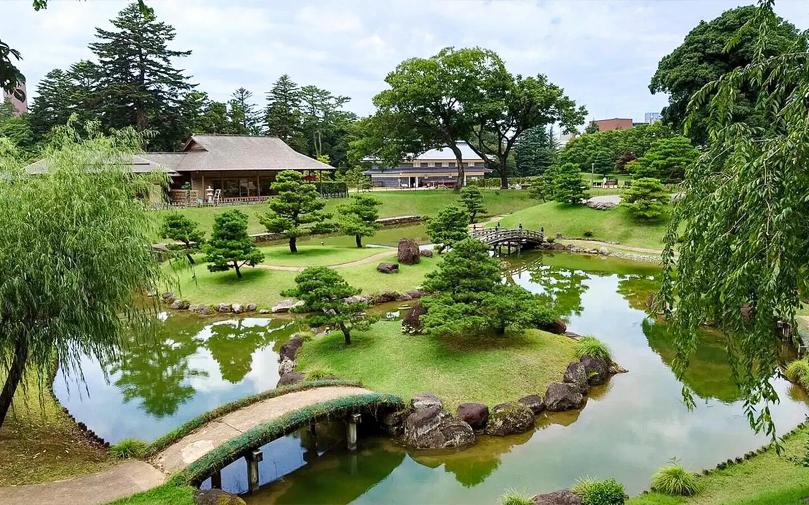 Kanazawa garden with traditional wooden house, pond, and arched bridge on 1-day tour.