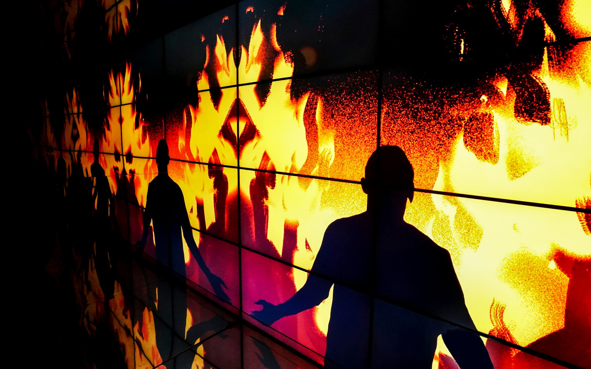 Silhouettes against flames at the firefighter exhibition in New Mill Water Tower, Prague.