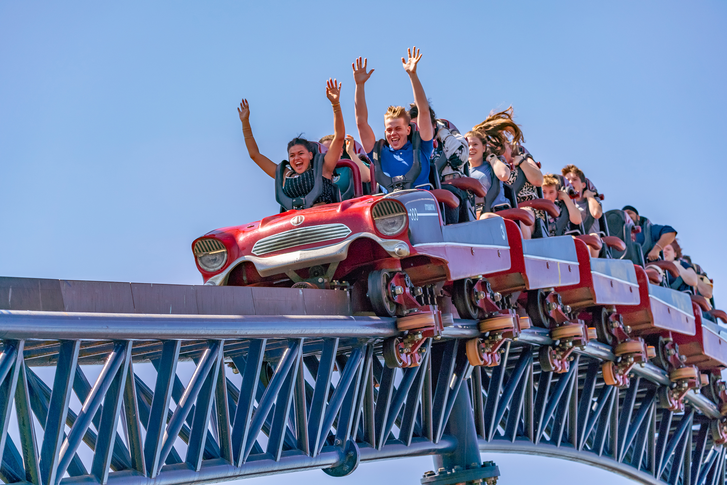 Thrilling ride on THE SWARM roller coaster at Thorpe Park Resort with riders' hands up.