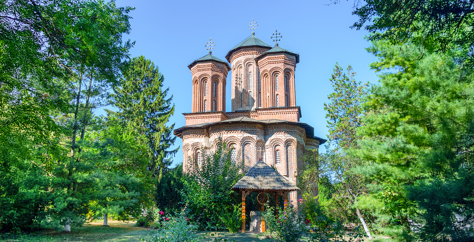 Snagov Monastery surrounded by lush greenery on a sunny day in Romania.