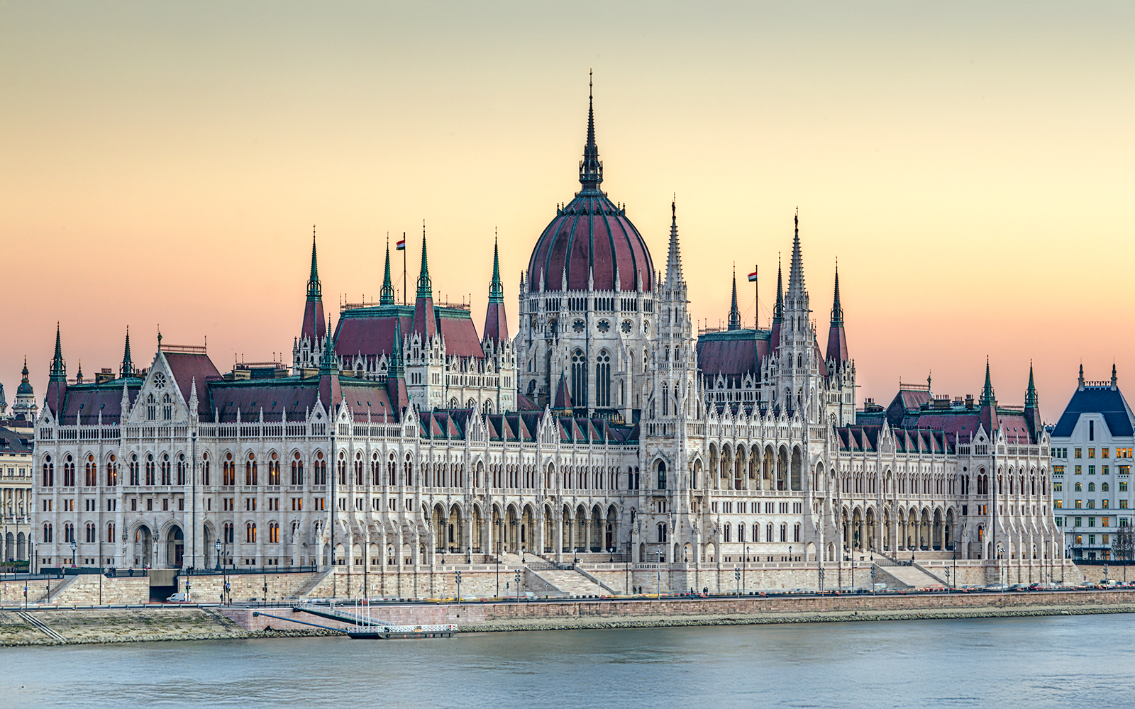 Parliament building in Budapest at dusk with river view.