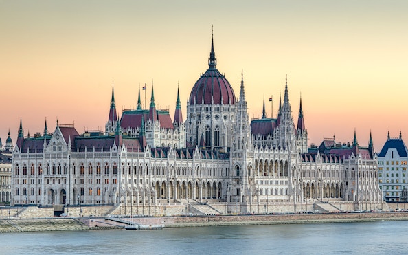 Parliament building in Budapest at dusk with river view.