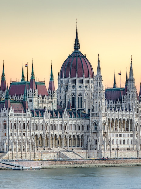 Parliament building in Budapest at dusk with river view.